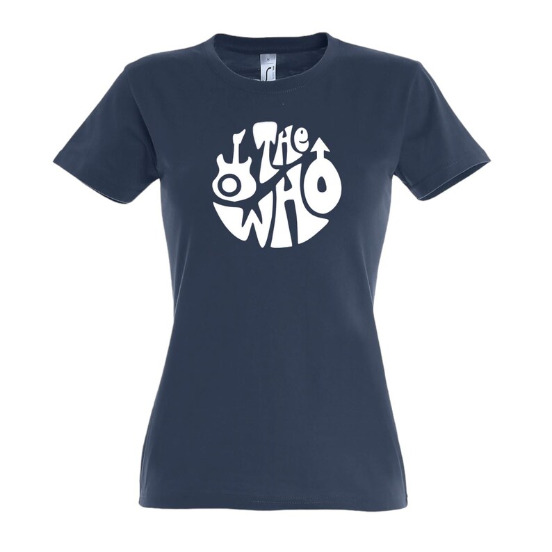 May include: A navy blue t-shirt with a white circular logo of the band "The Who". The logo includes a guitar and other symbols. The text "The Who" is in a stylized font. The t-shirt has short sleeves and a crew neck.