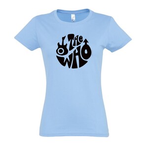 May include: Pale blue t-shirt with a black "The Who" logo. The logo is a circular design incorporating the band's name, a guitar, and a mod target symbol. A classic music-themed garment.