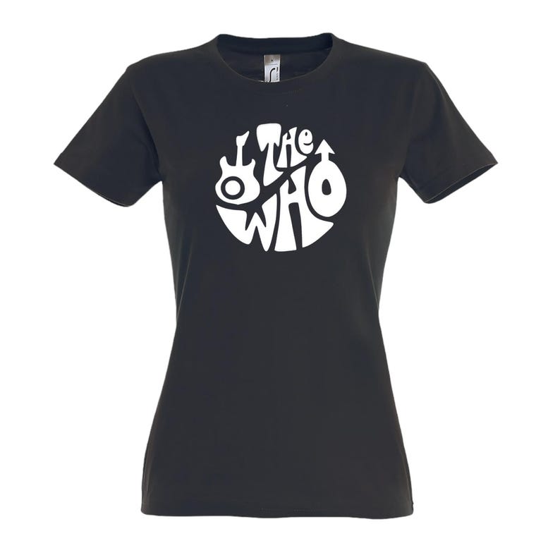May include: Black t-shirt with a white circular design featuring the band name "The Who" and various symbols. The shirt has short sleeves and a crew neck. The design includes a guitar and other symbols.