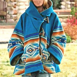May include: A blue hooded coat with a Southwestern-inspired pattern in shades of orange, blue, and white. The coat features a toggle closure and a cozy design, perfect for cooler weather. The sleeves and front panels showcase the detailed geometric print.