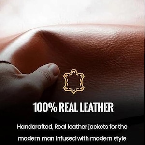 May include: Close-up of brown leather with the text "100% REAL LEATHER". The image shows a hand touching the leather. The text below reads "Handcrafted, Real leather jackets... and a touch of luxury."