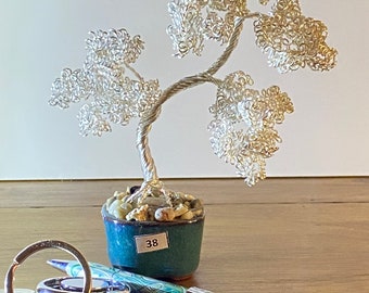 Silver wire mini bonsai tree mounted on a stone with pebble surround