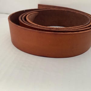 Puede incluir: Una tira de cuero marrón enrollada, ideal para proyectos de artesanía.