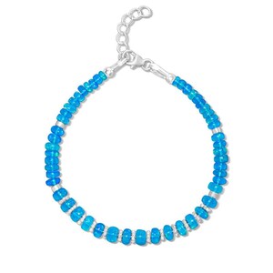 May include: A delicate bracelet featuring vibrant blue beads interspersed with silver-toned accents. The bracelet is designed with a classic chain and clasp closure, offering a touch of elegance. This piece is perfect for adding a pop of color to any outfit.