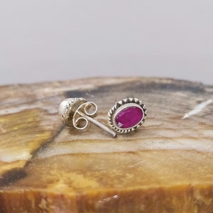 Peut inclure: Une paire de boucles d'oreilles en argent avec une pierre ovale rose sertie dans une bélière en argent.