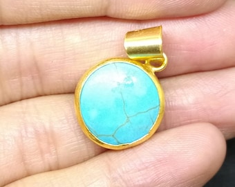 Peut inclure: Un pendentif en or avec une pierre ronde en turquoise. La pierre est de couleur bleu clair et présente un motif marbré.