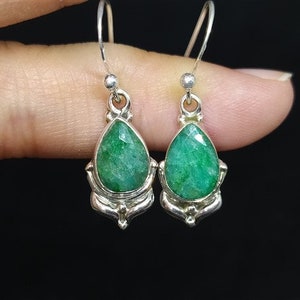 Pu&ograve; includere: Orecchini pendenti in argento con smeraldi sfaccettati a goccia. Le pietre verdi brillanti sono incastonate in montature d'argento decorate. Design classico ed elegante.