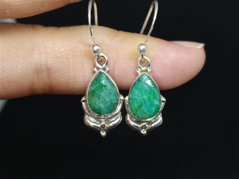 Pu&ograve; includere: Orecchini pendenti in argento con smeraldi sfaccettati a goccia. Le pietre verdi brillanti sono incastonate in montature d'argento decorate. Design classico ed elegante.
