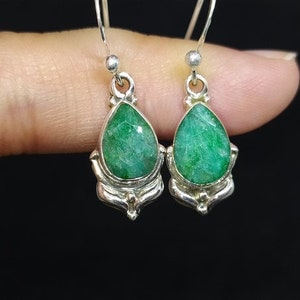 Pu&ograve; includere: Un paio di orecchini in argento con pietre preziose verdi a forma di goccia. Gli orecchini hanno una montatura in argento dettagliata con elementi decorativi. Le pietre preziose sono di un ricco colore verde smeraldo.
