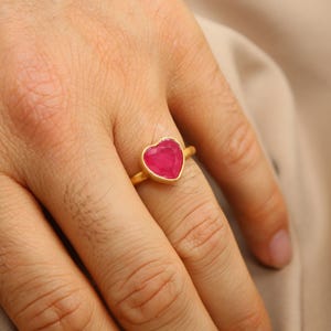 Peut inclure: Une bague en or avec une pierre précieuse en forme de cœur rose.