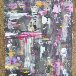 Könnte beinhalten: Abstrakte Acrylmalerei auf Leinwand mit einem strukturierten, geschichteten Effekt. Das Kunstwerk zeigt eine Palette von dunkelgrauen, schwarzen, weißen, rosa, gelben und violetten Pinselstrichen. Die Komposition ist eine Mischung aus vertikalen und horizontalen Strichen und erzeugt eine dynamische visuelle Textur.