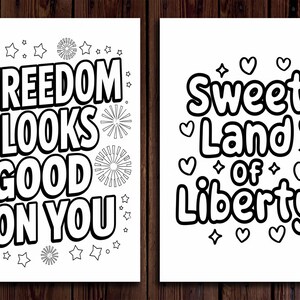 May include: Two black and white prints with patriotic themes. One says "Freedom Looks Good On You" with star and firework designs. The other says "Sweet Land of Liberty" with hearts and diamond shapes.