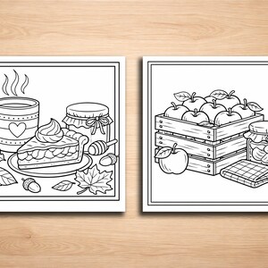 May include: Two black and white drawings of fall-themed items. One shows a mug, pie, jar of honey, and leaves. The other depicts a wooden crate filled with apples, a jar of preserves, and a checkered cloth.