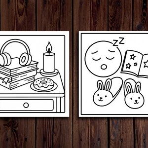 May include: Two black and white illustrations on a wooden background. One shows headphones, books, a candle, and a donut. The other depicts a sleeping emoji, a book with stars, and bunny slippers. The illustrations are framed.