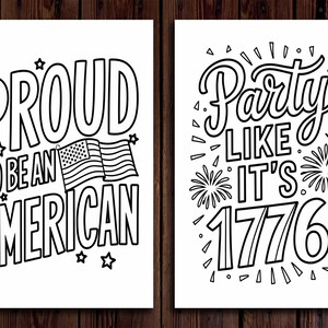 May include: Two black and white prints on white backgrounds. The left print reads "PROUD TO BE AN AMERICAN" with an American flag graphic. The right print says "Party LIKE IT'S 1776" with fireworks and an American flag graphic. Both are on a wood background.