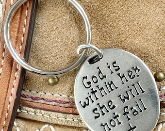 May include: Silver keychain with a round charm that reads "God is within her she will not fail" with a cross at the bottom.