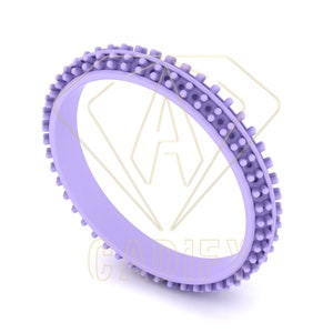 Może przedstawiać: Fioletowy silikonowy pierścionek z fakturowanym zewnętrznym brzegiem. Pierścionek został zaprojektowany tak, aby zapewnić wygodne i bezpieczne dopasowanie.