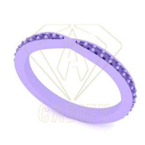 Puede incluir: Un anillo de silicona de color lavanda con una banda texturizada. La banda tiene una serie de pequeños bultos alrededor de toda la circunferencia.