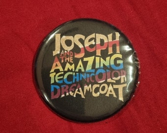 May include: A black button with a rainbow design that reads "Joseph and the Amazing Technicolor Dreamcoat".