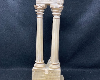 May include: A white plaster model of a Roman temple ruin with two columns and a partially destroyed archway. The inscription "ESTIVER" is visible on the archway. The base of the model is inscribed with "TEMPIO DI".
