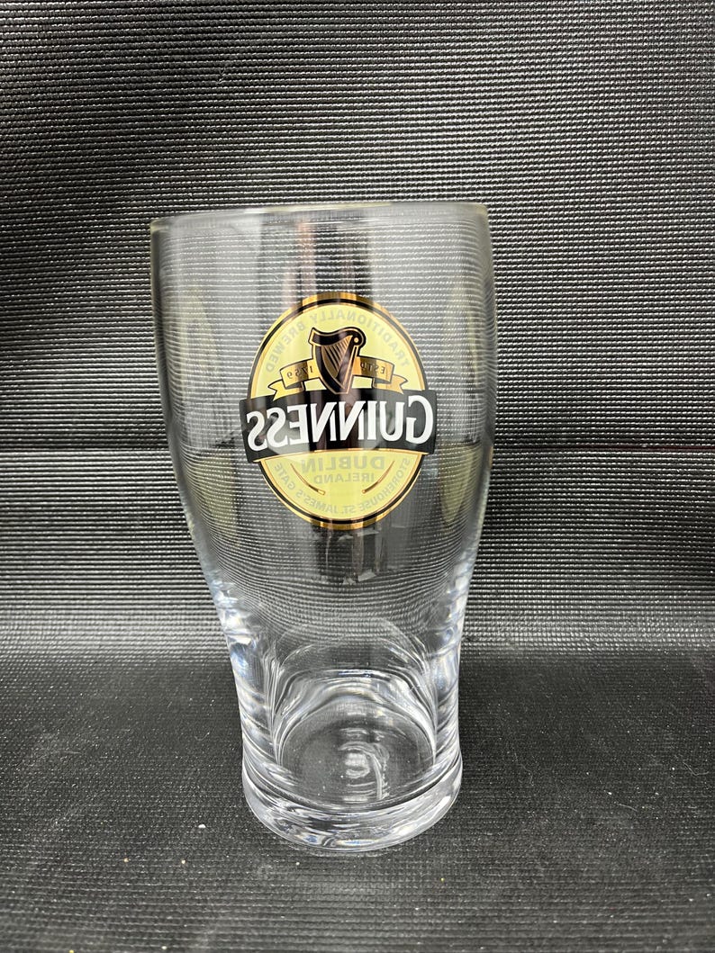 May include: A white ceramic mug with a black handle and the text "But First, Coffee" in a black, bold font. The mug is on a white surface. The mug is approximately 4 inches tall.