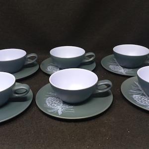 May include: Set of six blue and white teacups and saucers with a pine cone design.