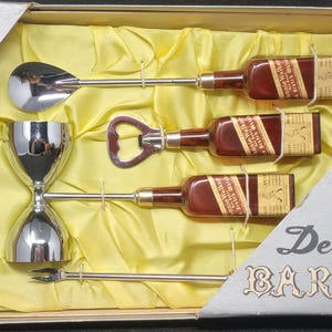 May include: A vintage chrome bar set in a box with the words "Triple Plated Chrome" and "Deluxe Bar Set". The set includes a jigger, a bottle opener, a spoon, and three miniature liquor bottles.