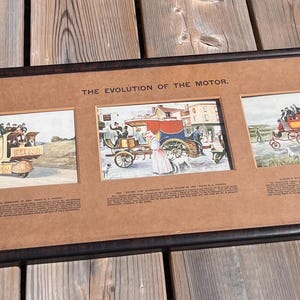 May include: A long, rectangular black-framed wall art piece titled THE EVOLUTION OF THE MOTOR. It features five separate colour illustrations depicting historical vehicles and carriages, each accompanied by descriptive text on a tan mat board background.