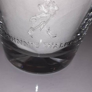 May include: A clear glass tumbler with a frosted design featuring the Johnnie Walker logo and a striding man figure.
