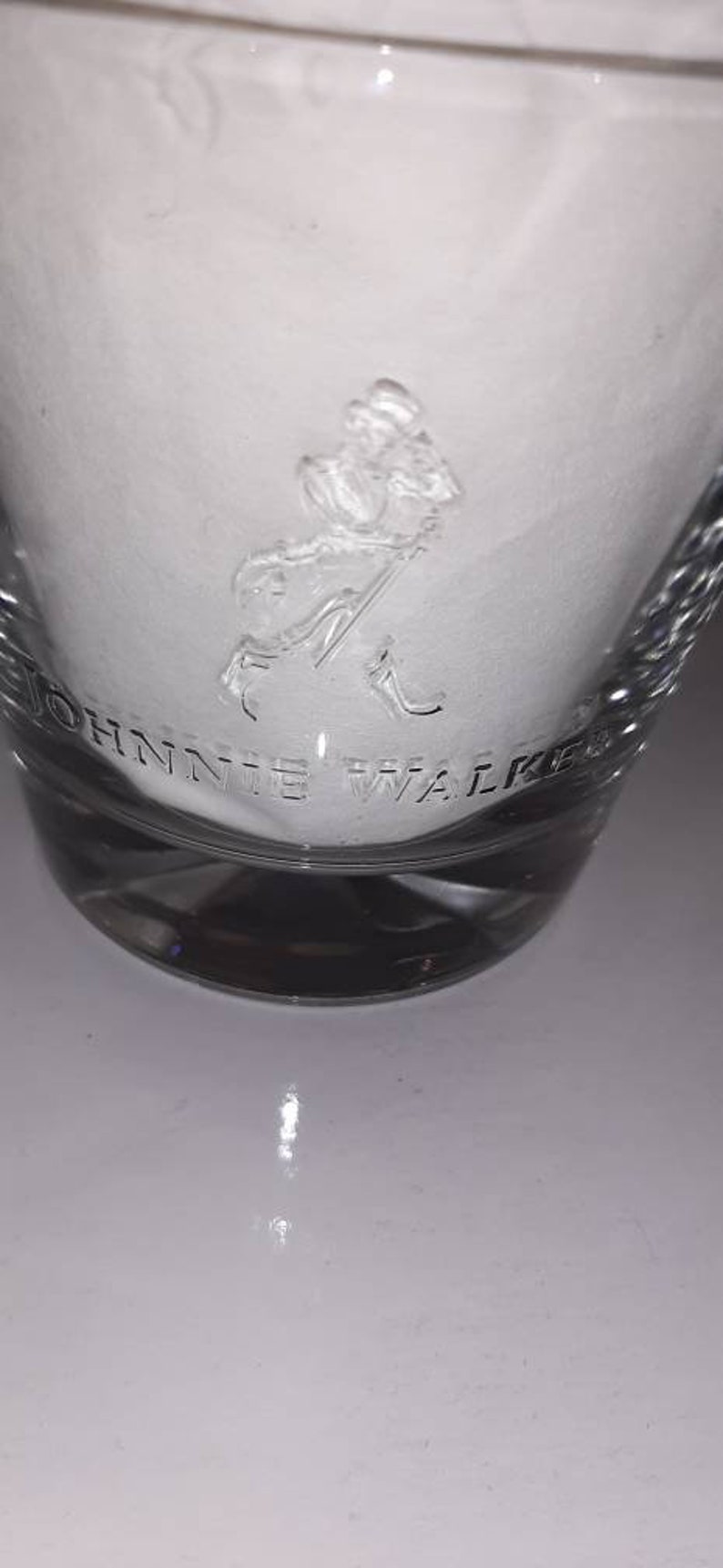 May include: A clear glass tumbler with a frosted design featuring the Johnnie Walker logo and a striding man figure.