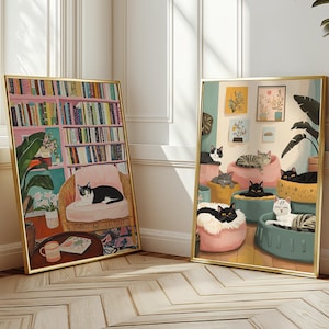 May include: Two framed art prints with gold frames. One depicts a cat in a pink chair in front of a bookshelf. The other shows several cats lounging in various beds. The artwork has a cozy, inviting feel.