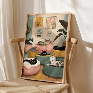 May include: A framed art print featuring a whimsical illustration of several cats lounging in colorful beds. The cats have various markings, including black, gray, and tabby patterns. The artwork is set against a light background with decorative plants.