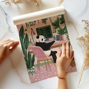 Op de afbeelding: Een pandabeer zit aan een roze bureau met een computerscherm waarop code wordt weergegeven. De panda draagt een zwart-witte vacht en heeft een roze stoel. Het bureau is omringd door planten en bloemen.