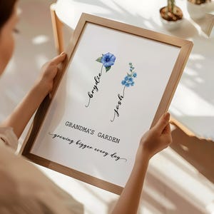 May include: A framed print with a watercolor illustration of two blue flowers. The text "Grandma's Garden growing bigger every day" is written below the flowers. The names "Brydie" and "Josh" are written in cursive above the flowers.
