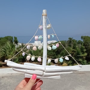 White handmade wooden boat with sea shells