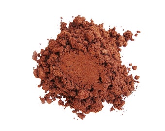 May include: A close-up of a pile of loose, reddish-brown mica powder. The powder is finely ground and has a shimmery, metallic finish.