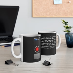 May include: White ceramic mug with a black and red design featuring the HAL 9000 computer from the movie 2001: A Space Odyssey. The mug has a text overlay that reads "I know everything hasn't been quite right with me but I can assure you now very confidently, that it's going to be all right again. I feel much better now. I really do...but get your own damn coffee!"