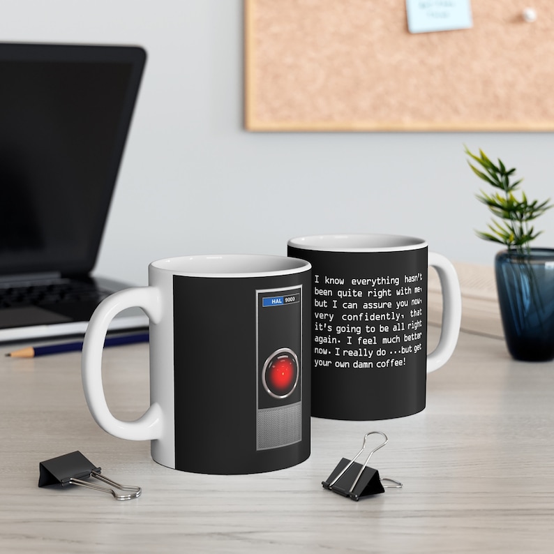 May include: White ceramic mug with a black and red design featuring the HAL 9000 computer from the movie 2001: A Space Odyssey. The mug has a text overlay that reads "I know everything hasn't been quite right with me but I can assure you now very confidently, that it's going to be all right again. I feel much better now. I really do...but get your own damn coffee!"