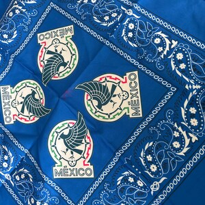 May include: A vibrant blue bandana featuring the Mexican national emblem repeated four times. The emblem includes a stylized eagle, a soccer ball, and the word "MEXICO". The border has a white paisley design.