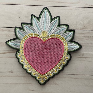 Könnte beinhalten: Gestickter Bügel-Patch mit einem rosa Herz mit einem gelben und grünen Blumendesign.
