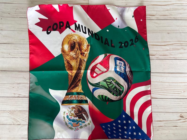 May include: A square fabric with a soccer theme. It features the FIFA World Cup trophy, a soccer ball, and flags of the United States, Canada, and Mexico. The text "COPA MUNDIAL 2026" is also present.