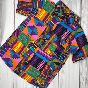 May include: A short-sleeved button-up shirt with a colorful geometric pattern in shades of orange, purple, green, blue, and black.