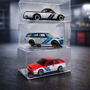 May include: A set of three ceramic mugs with a speckled, matte finish. The mugs are in shades of cream, light gray, and dark gray. Each mug has a simple, minimalist design and a rounded handle. The mugs are likely for coffee or tea.