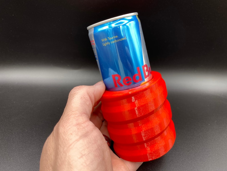 May include: Red can of Red Bull energy drink in a red 3D printed can holder.