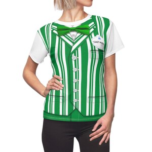 May include: A white t-shirt with a green and white striped vest printed on it. The vest has a bow tie, buttons, and pockets. The shirt also has a name tag that says "Cast Member".