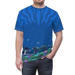 May include: A blue t-shirt with a graphic print of a dark blue, starry night sky with a green, rocky landscape at the bottom. The landscape features purple and pink flowers.