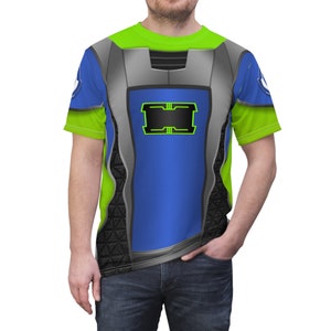 May include: A green, blue, and gray short-sleeved t-shirt with a futuristic design. The shirt features a black rectangle with a green outline and a gray border.