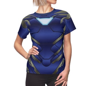 May include: A blue and gold t-shirt with a metallic design. The design resembles a superhero's chest plate.