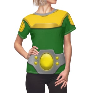 May include: A green and yellow t-shirt with a silver belt and a large yellow circle in the center. The shirt has a short sleeve and a crew neck.