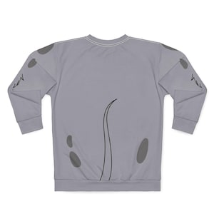 Puede incluir: Una sudadera gris claro con mangas largas. La parte posterior de la sudadera presenta una línea negra curva y varias formas ovaladas grises. Las mangas tienen un diseño gris. La sudadera está hecha de un material suave.